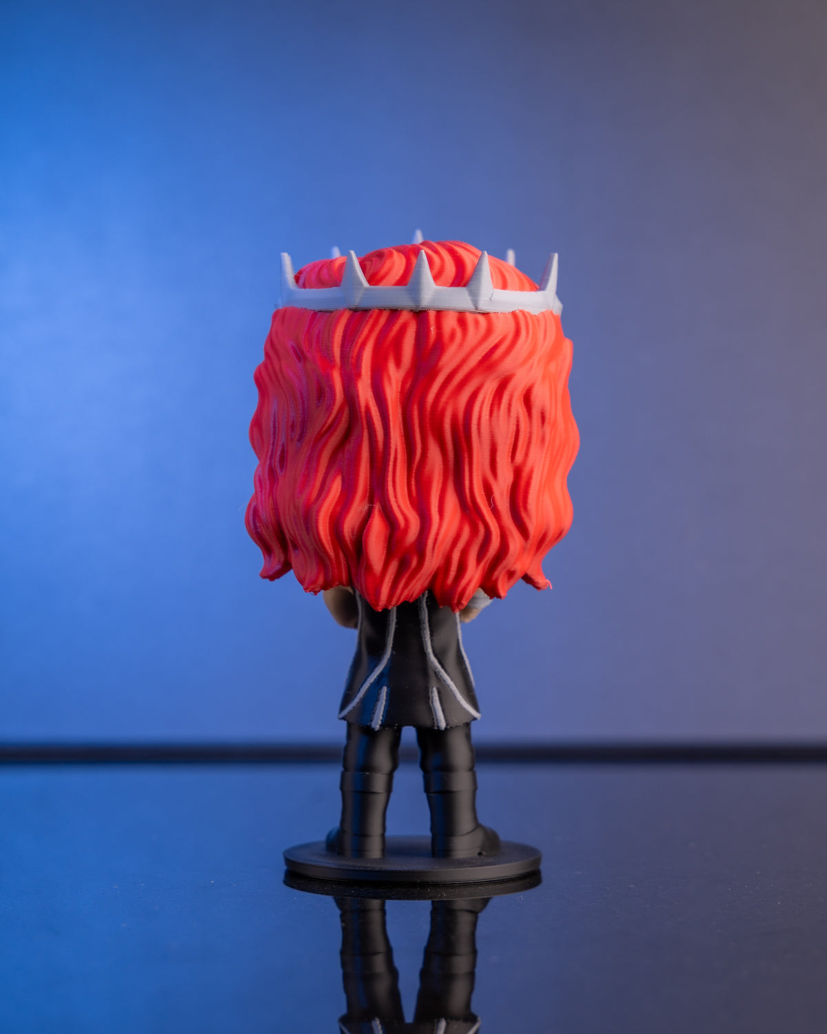 The Silver-Eyed King figure from behind — long red hair and spiked silver crown